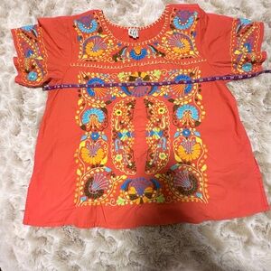 Sister Mary Top. Vibrant coral with multi colored embroidery.